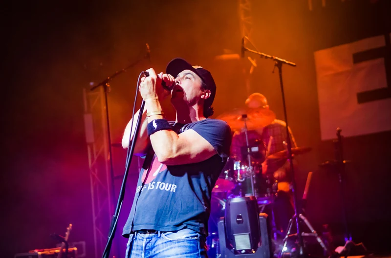 Band members performing under red lights