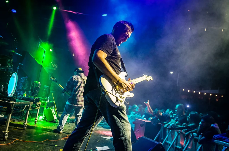 Guitarist under green stage lights